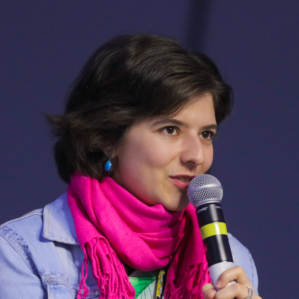 Foto de Caroline Burle segurando um microfone